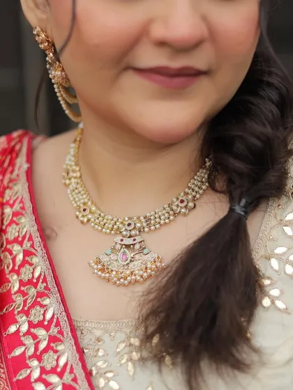 A close-up on the jewelry and the subtle makeup. You can see the soft lip color and the clean, natural finish on the skin.