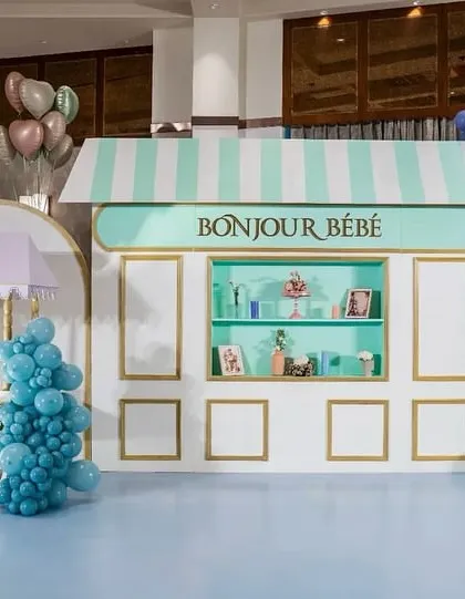 Bonjour Bébé! We transported guests to a Parisian street with this charming baby shower setup. Featuring a custom patisserie facade, a Ladurée-inspired cart, and vibrant balloon garlands, this theme is perfect for a chic and stylish celebration.