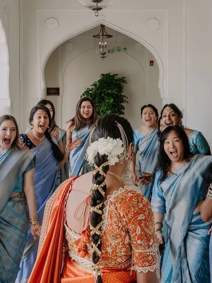 The priceless reaction of the bridesmaids seeing their friend as a bride for the first time. A moment of pure surprise and joy.