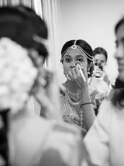A bride dabs a tear while getting ready, a moment of overwhelming emotion.