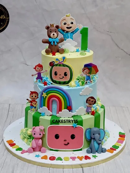 A grand three-tier Cocomelon cake, perfect for a first birthday. This cake brings the beloved characters to life with edible figures, fondant rainbows, and a cheerful design that will have all the kids singing.