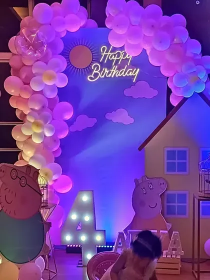 A fun and playful Peppa Pig theme. This setup includes a house backdrop, character cutouts of the Pig family, and a balloon arch with cute flower details, perfect for a 4th birthday party.