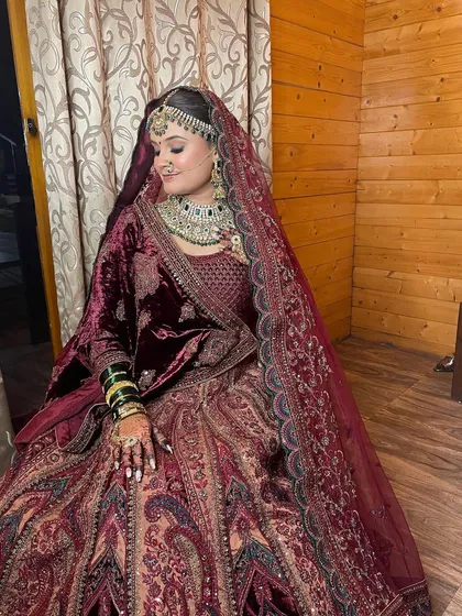 Showcasing the royal elegance of this bride's reception look, with soft glam makeup that complements her rich velvet lehenga.