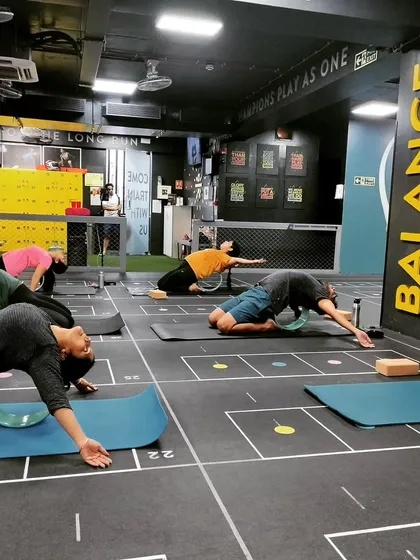 We often use props like the yoga wheel to safely deepen backbends and open the heart space. Here, students are exploring Anahatasana (Melting Heart Pose) with the support of the wheel.
