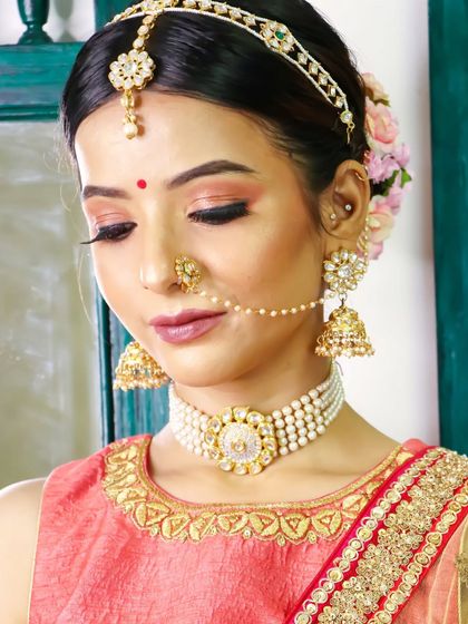 The right amount of color is key. This look features soft, rosy tones on the eyes and cheeks to complement the bride's pink and gold outfit.