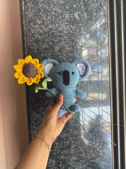 A sweet Koala amigurumi holding a bright yellow sunflower. This was a custom request, and I loved combining the cute animal with a pop of floral color.