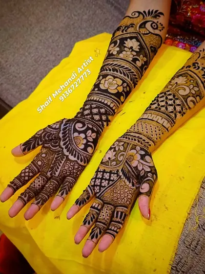 The contrast between the dark henna paste and the skin is what makes a fresh design so striking. This full-arm bridal mehandi combines bold peacock figures with delicate floral and geometric patterns for a balanced look.