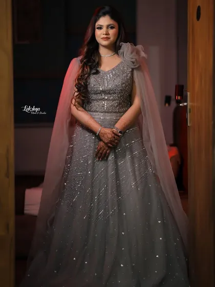 A full-length portrait of the bride looking radiant in her grey engagement gown. The soft lighting and elegant pose create a timeless look.