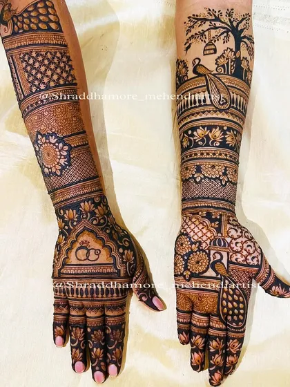 A picturesque design featuring a peacock under a tree on the forearm. The hands are filled with engagement rings and another peacock motif.