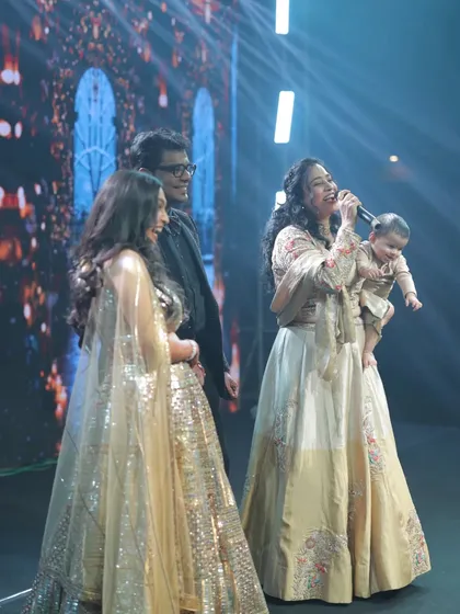 Here I am, a proud working mom, hosting a large sangeet ceremony with my daughter Gauri in one arm and the microphone in the other. This moment captures my core belief: women can balance their professional passions and motherhood. I help brands connect with this empowered audience.