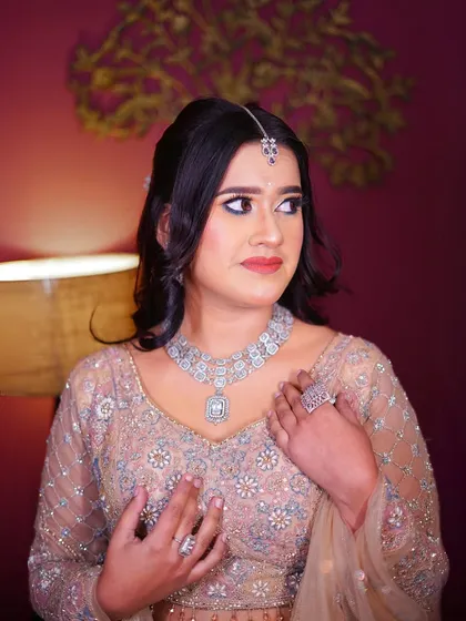 A close-up portrait highlighting the diamond necklace and soft, neutral makeup tones.