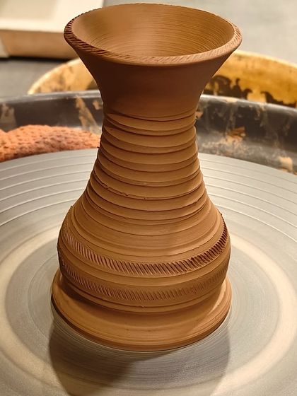 A freshly thrown vase, showcasing the clean lines and textures you can create on the pottery wheel.