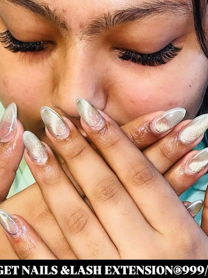 This combo features cat-eye effect silver nail extensions and a dense set of lash extensions for a bold, glamorous look.