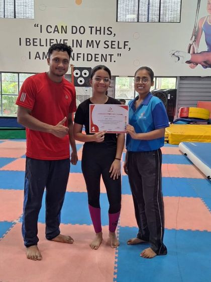 A student receives her Level 1 proficiency award, celebrating her successful start in the world of competitive gymnastics.