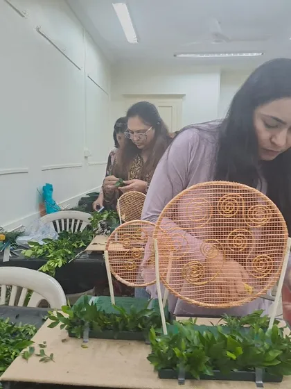 This student is focused on building the foundation of her Diwali arrangement. We provide all the necessary materials, including unique frames and fresh foliage, for students to bring their ideas to life.