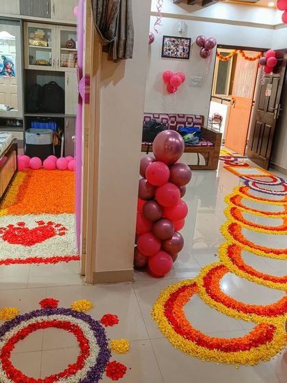 A full view of the beautiful flower rangoli for a baby welcome ceremony. The entire hallway is transformed into a colorful and festive space to greet the newborn.