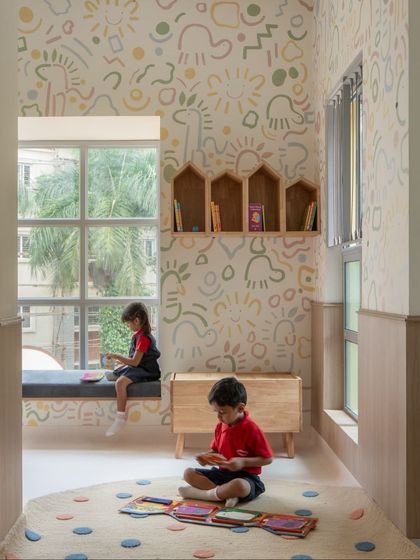 Children enjoying one of the cozy reading nooks. The combination of a soft window seat for looking outside and a plush rug for sitting on the floor gives them options for how they want to relax and read.