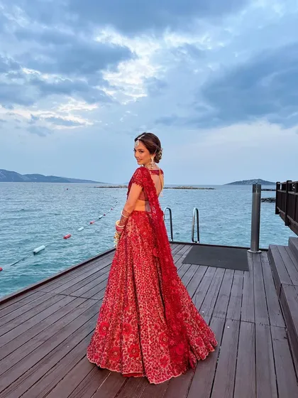 A full-length shot of the bride, her elegant updo complementing the dramatic backdrop of the sea.