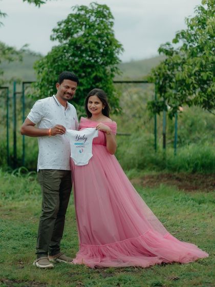 Announce your joy to the world. This pink off-shoulder gown is perfect for those special announcement shots, comfortably fitting around the baby bump while you share your exciting news.