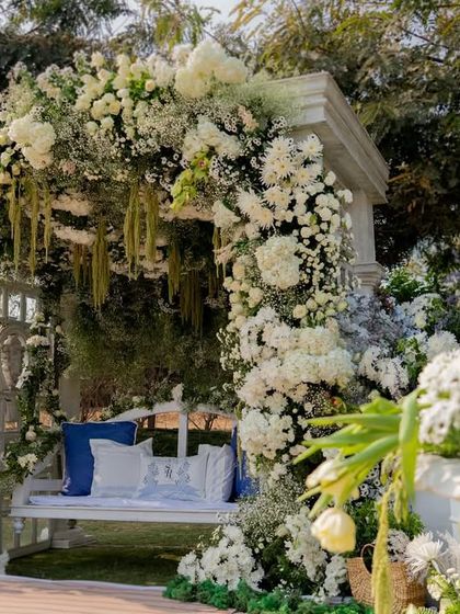 A Haldi ceremony with a twist. We used a sophisticated palette of white, green, and blue for a fresh and modern take on the traditional event. The floral arch over the swing is pure elegance.