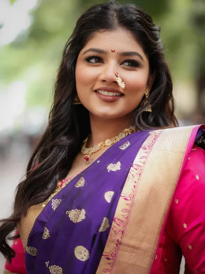 A close-up of a beautiful bride. The makeup is soft and glowing, with a focus on her expressive eyes and beautiful smile.