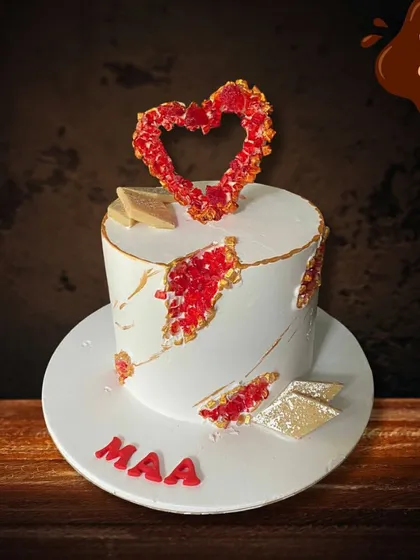 A simple yet beautiful cake to celebrate "Maa". This design features a modern fault line style with red crystal details and is topped with a delicate sugar work heart, showing love in every slice.