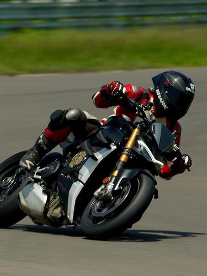 A close-up of the Ducati Streetfighter V4, showcasing the rider's control and the bike's aggressive stance while cornering.