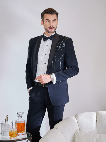 This black tuxedo showcases modern, geometric hand-embellishments on one side, offering an asymmetrical and artistic flair. It's a perfect choice for the groom or groomsman looking for a unique yet formal outfit.