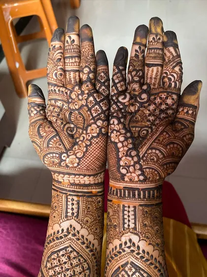 A view of the palms of a full bridal mehendi. The design is packed with detail, ensuring that the richest color develops in the area where it matters most.