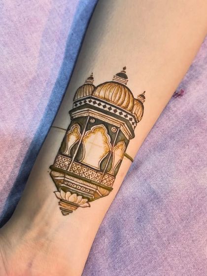 A simple temple motif drawn on the arm. This is a great example of a small, elegant henna tattoo.