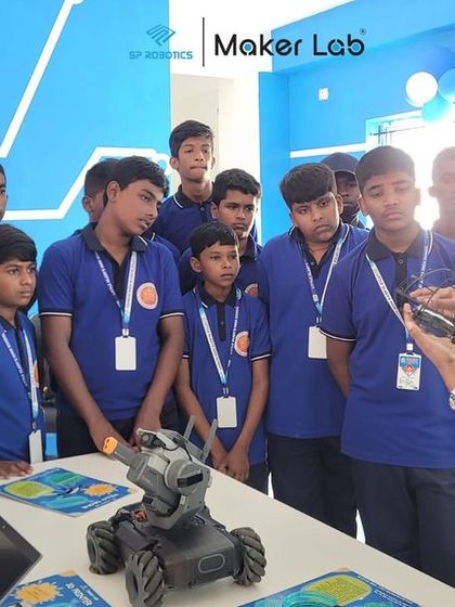 An instructor explains the mechanics of a targeting robot to a group of students, demonstrating concepts of automation and precision.