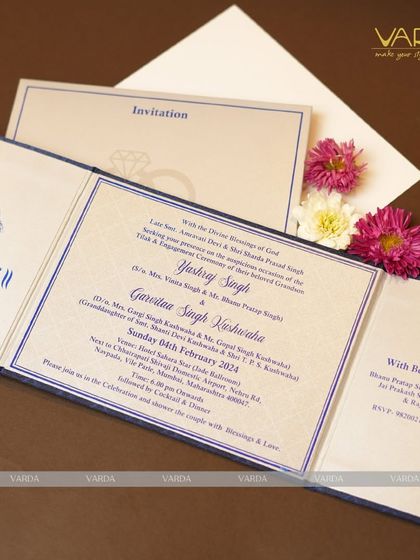 A classic tri-fold engagement invitation in a royal blue and white color scheme. The clean layout, elegant font, and traditional Ganesha motif printed in blue offer a perfect balance of modern design and customary respect.