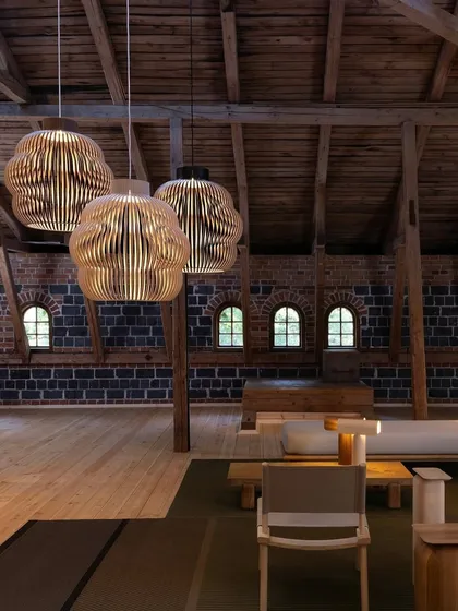 I believe in the warmth and timelessness of natural materials. These sculptural pendants, crafted from Finnish birch wood, bring an organic softness to this rustic loft. Their slatted design casts intricate patterns of light and shadow, enhancing the architectural character of the space.