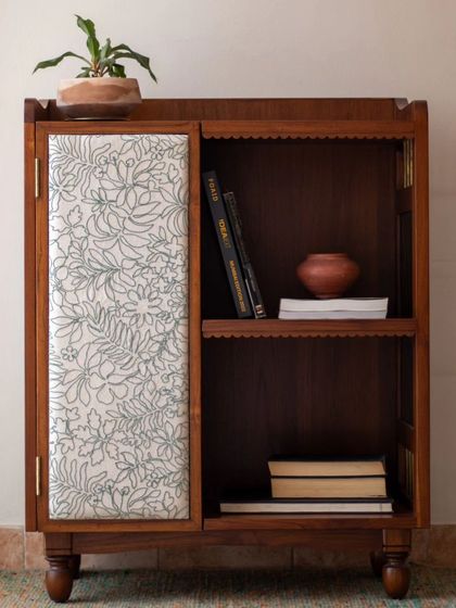 The Aamira storage unit is a piece with details galore. It can function as a bookcase, crockery unit, or bar, and features finger grooves, stained glass, and brass inserts, making it a statement piece for any living or dining area.