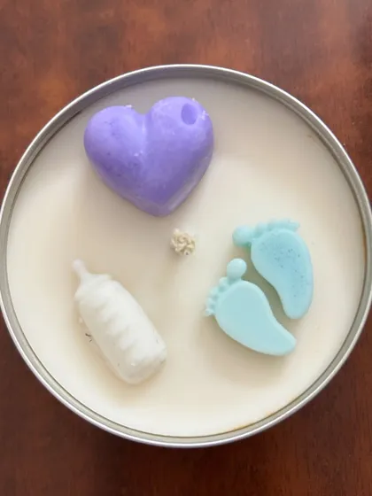 A top-down view of our baby shower candle. The little wax elements are made from the same soy wax and add a playful touch to the gift.