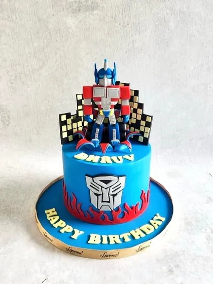 An Optimus Prime cake for a Transformers fan. The cake is topped with a detailed figurine and the Autobots logo.