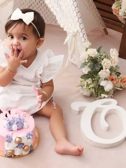 That first taste of frosting. I love capturing the focused, curious expressions babies make during their cake smash. This close-up is a perfect memory of her first birthday treat.