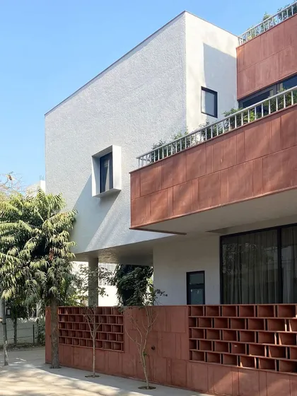 This view of the Jaipur House captures the layering of architectural elements. The projecting balcony and recessed windows create a play of light and shadow, adding depth and character to the building's exterior.