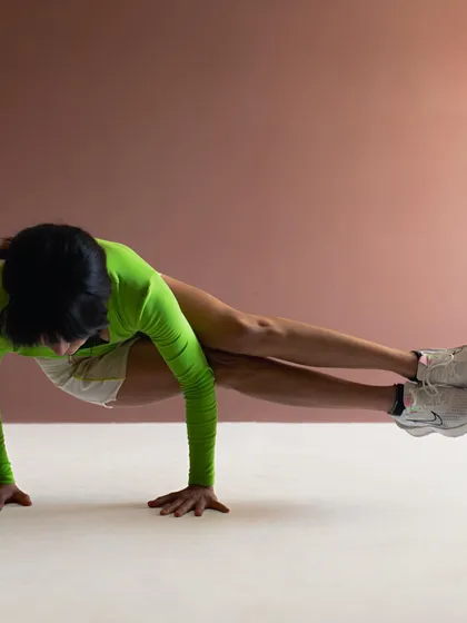 A full-body shot demonstrating a difficult pose. The lighting is set up to accentuate muscle definition and form.