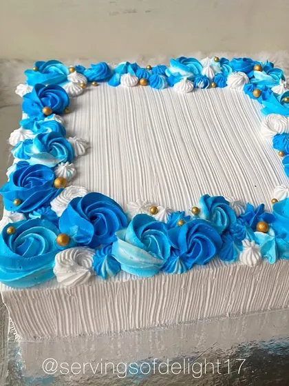 Another angle of the blue floral sheet cake, showing the texture of the buttercream and the two-tone rosettes.