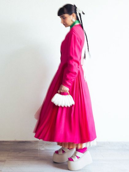 A full side view showcasing the incredible platform shoes and the fan-like handbag, which were key accessories for this look.