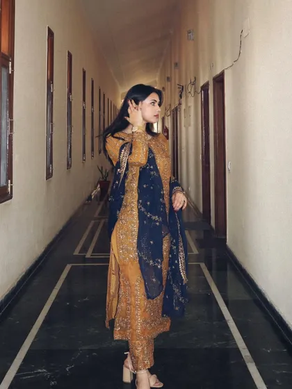 A side profile shot in the Asim Jofa suit, showing how the outfit looks while in motion and highlighting the flow of the dupatta.