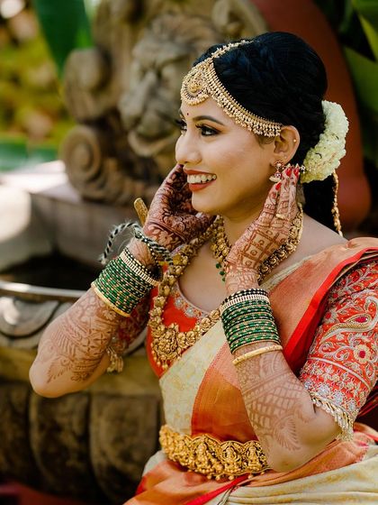 The joy of a bride on her wedding day. Annanya looks absolutely radiant in her full bridal jewellery set, featuring a statement matha patti, choker, haram, and vaddanam with intricate temple motifs.
