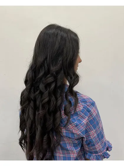 A side view of the perfectly curled long hair, showing the consistency and bounce of the curls.
