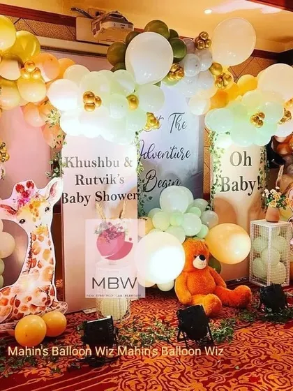A closer look at the adventure-themed baby shower, showing the charming details of the animal props and the soft, cloud-like balloon clusters.