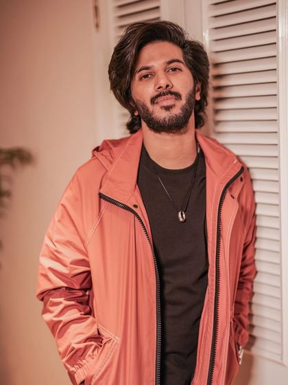 Dulquer Salmaan in a casual yet stylish Paul Smith jacket. The pop of coral adds a nice bit of color to the simple black t-shirt and jeans.