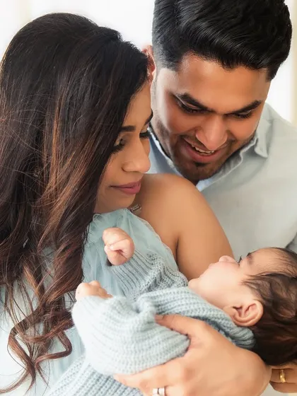 A new family of three, admiring their greatest creation. This lifestyle portrait captures the awe and love that fills the room during a 3-month baby photoshoot.