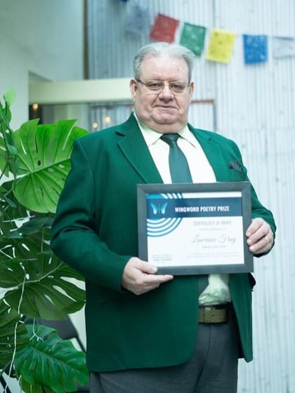 Lawrence Fray, a winner in the main category, proudly holds his framed certificate of merit.