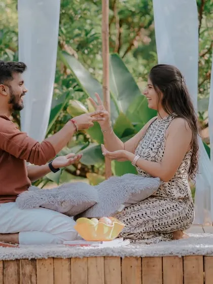 A playful pillow fight during a picnic-style pre-wedding shoot. This fun and energetic activity brings out genuine laughter and creates dynamic, memorable photos that show the couple's lighthearted connection.