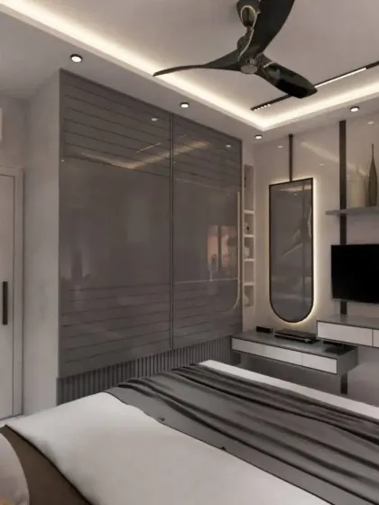 This angle shows the glossy grey sliding wardrobes and the integrated vanity unit, creating a seamless and stylish storage solution.